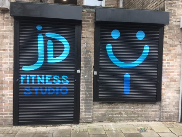The Joyride entrance with black shutters and blue artwork